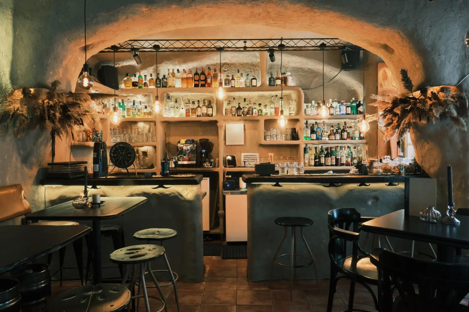 Interior of Orange Bar — cave-like vaulted bar with backlit bottle shelves